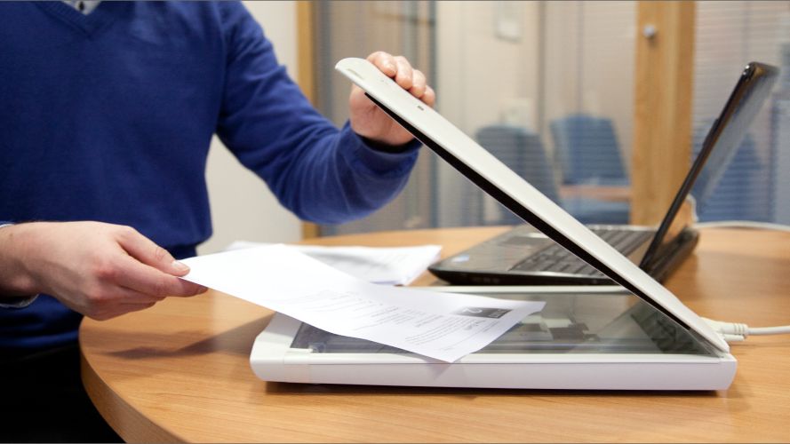 Person placing a document in a scanner.